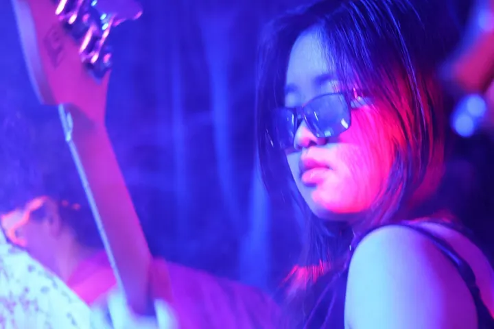 Bassist in sunglasses under blue light