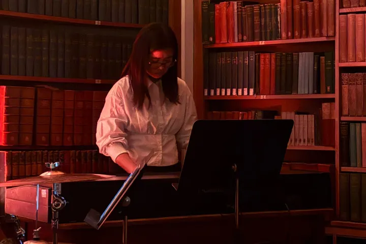At the keyboard under red light in the library