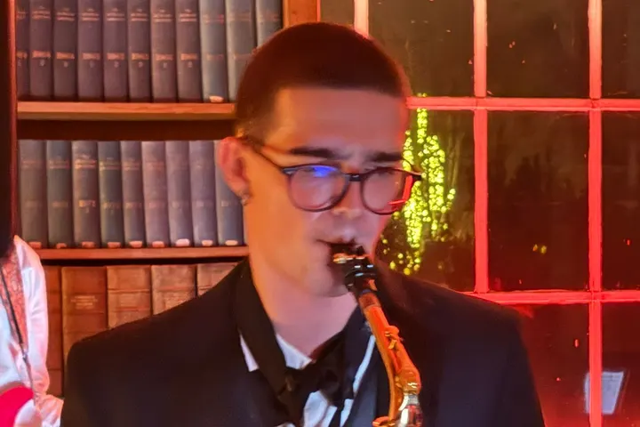 Alto sax solo in a bow tie, lit red