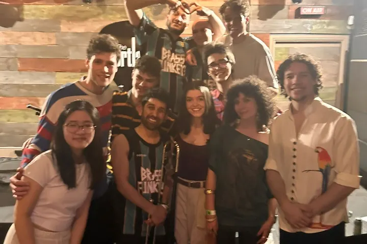 The band crowded together backstage after a gig